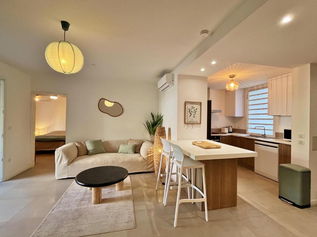 eine Küche und ein Wohnzimmer mit einer Couch und einem Tisch in der Unterkunft Appartement Club Ocean in L'Ermitage-Les-Bains