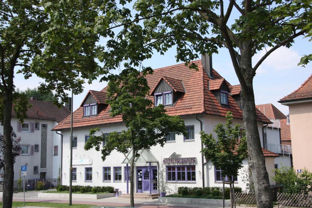 ein weißes Gebäude mit rotem Dach in der Unterkunft Art-Hotel Erlangen in Erlangen