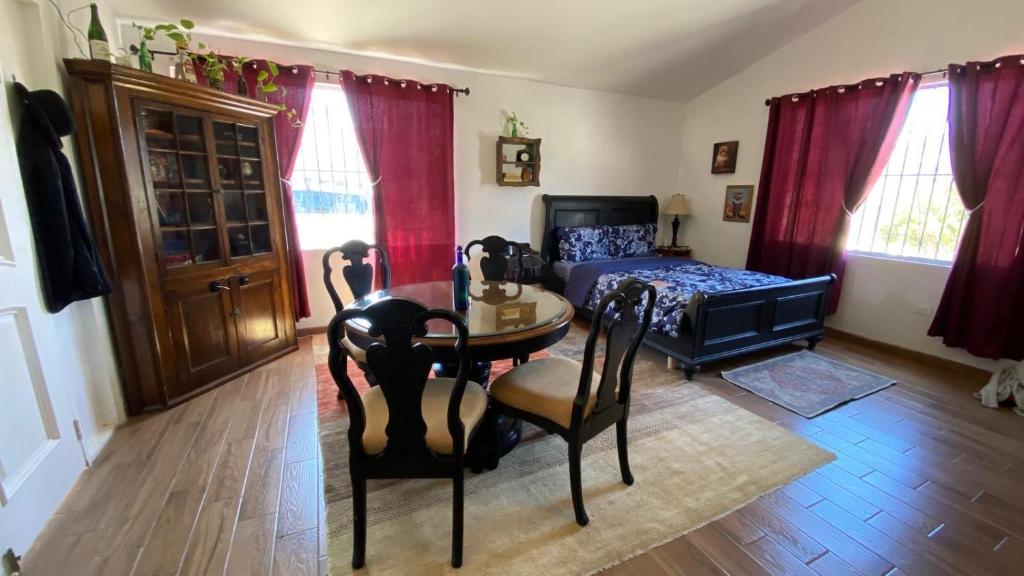 a bedroom with a bed and a table and chairs at Guest Studio near Businesses and Markets in Ensenada