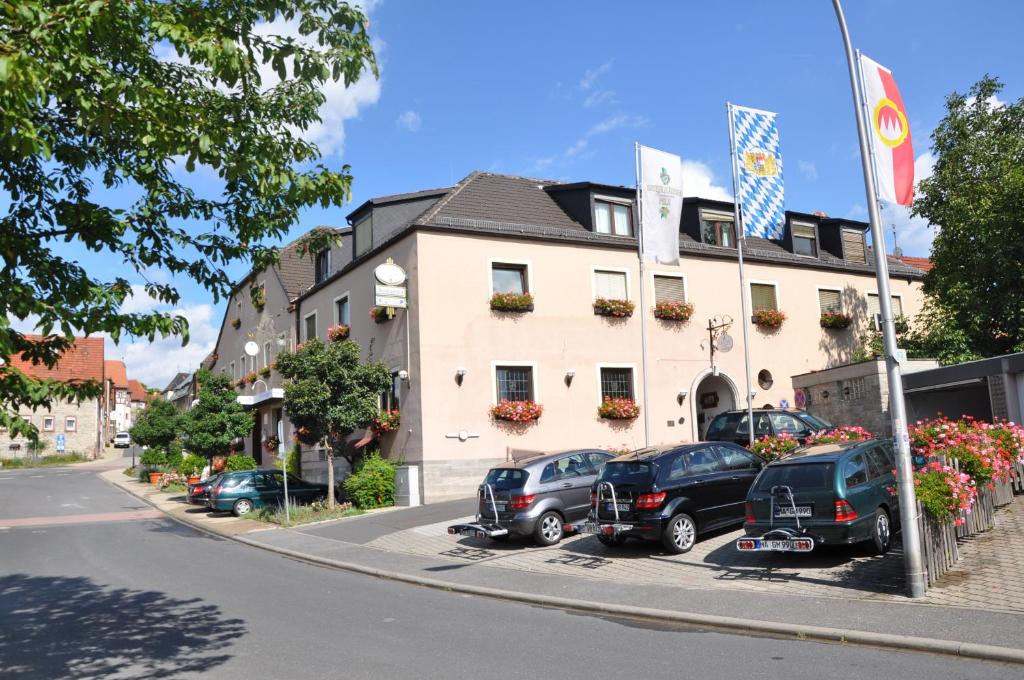 une rue avec des voitures garées devant un bâtiment dans l'établissement Hotel Gasthof Vogelsang, à Zellingen