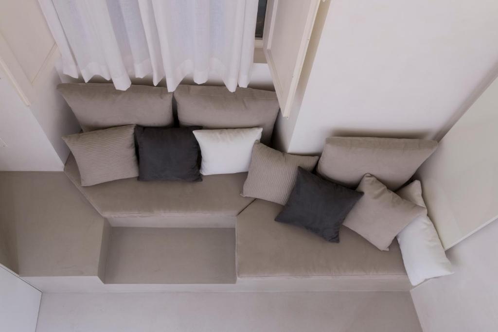 - un canapé avec des oreillers dans l'établissement Solo per Noi Apartment, à Sienne