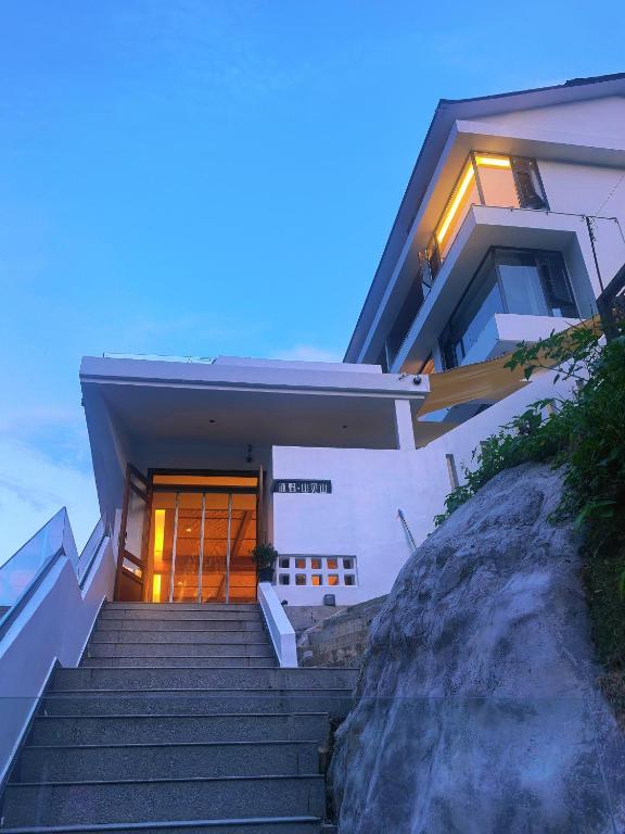 een huis met een trap naar een deur bij Zhangjiajie MUYE HOTEL in Jiawan