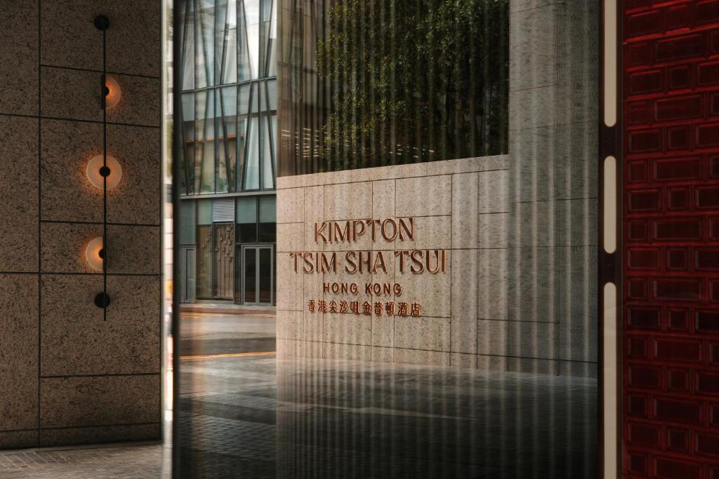 een bord aan de zijkant van een gebouw bij Kimpton Tsim Sha Tsui Hong Kong in Hong Kong