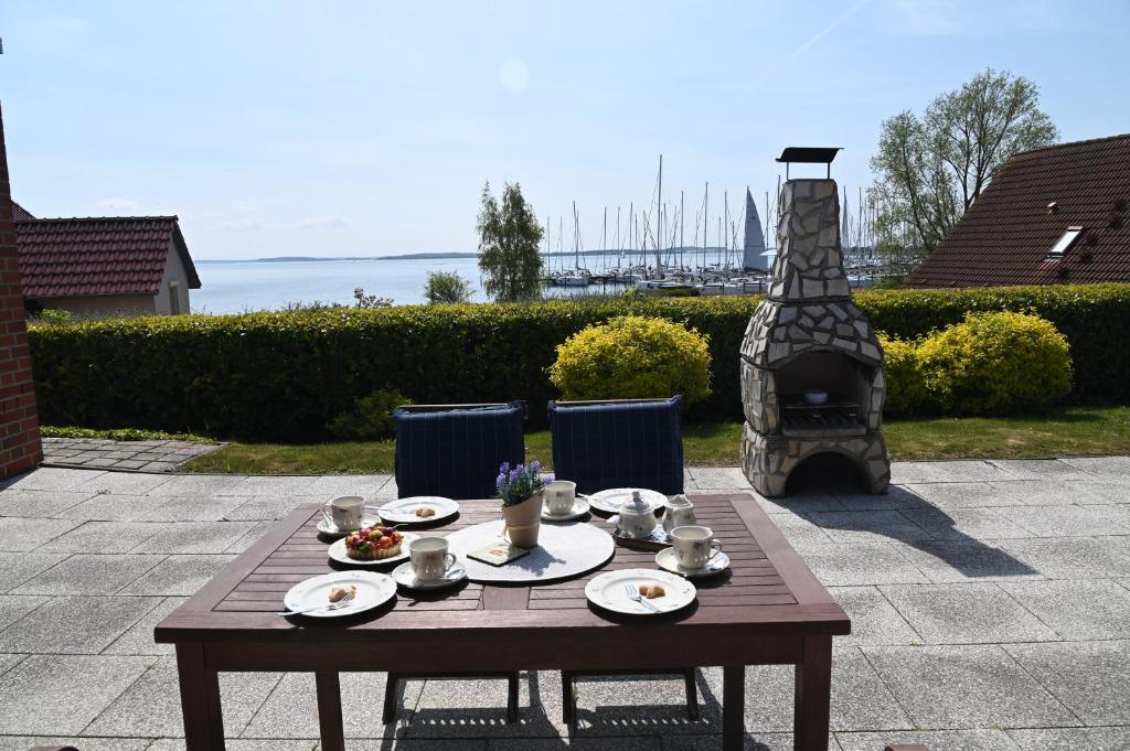 a wooden table with plates of food and a fireplace at Haus Boddenperle in Breege