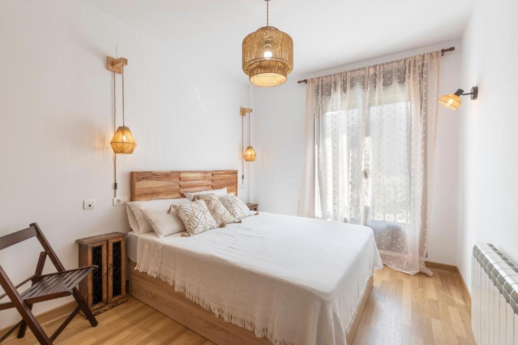 ein weißes Schlafzimmer mit einem Bett und einem Fenster in der Unterkunft Entre gigantes, La Alhambra y Sierra Nevada in Güéjar-Sierra