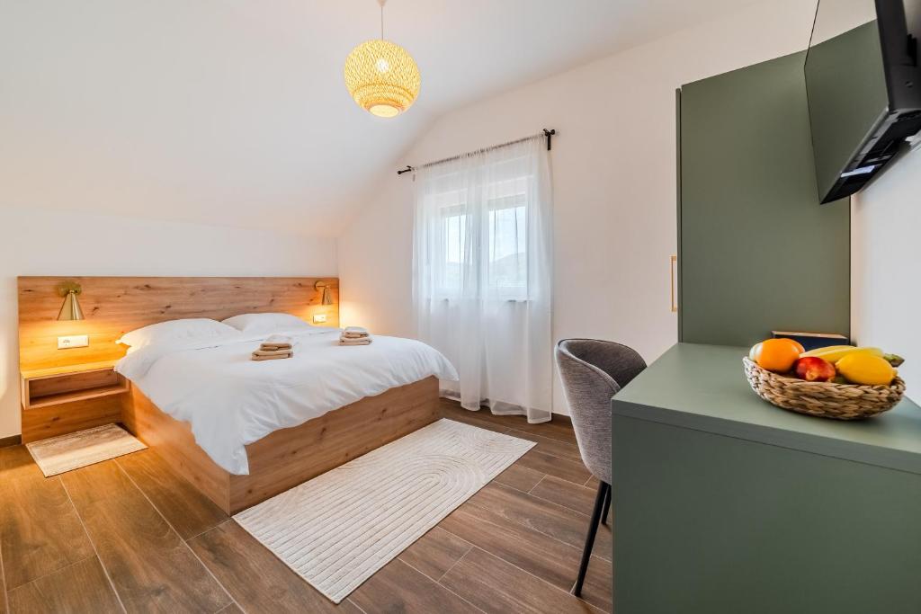 Un dormitorio con una cama y un bol de fruta. en Plitvice Lakes Apartments & Rooms, en Grabovac
