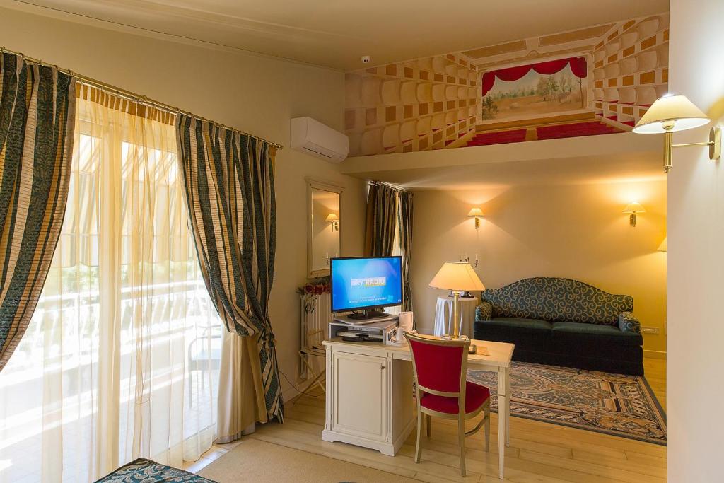 Televízia a/alebo spoločenská miestnosť v ubytovaní Hotel Serenella