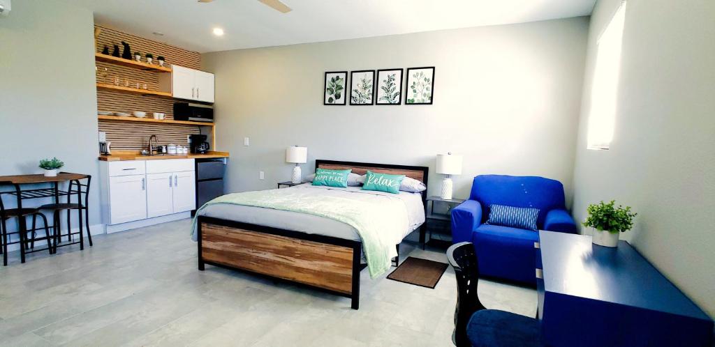 a bedroom with a bed and a blue chair at Charming studio in fabulous University Pines in Desoto Lakes