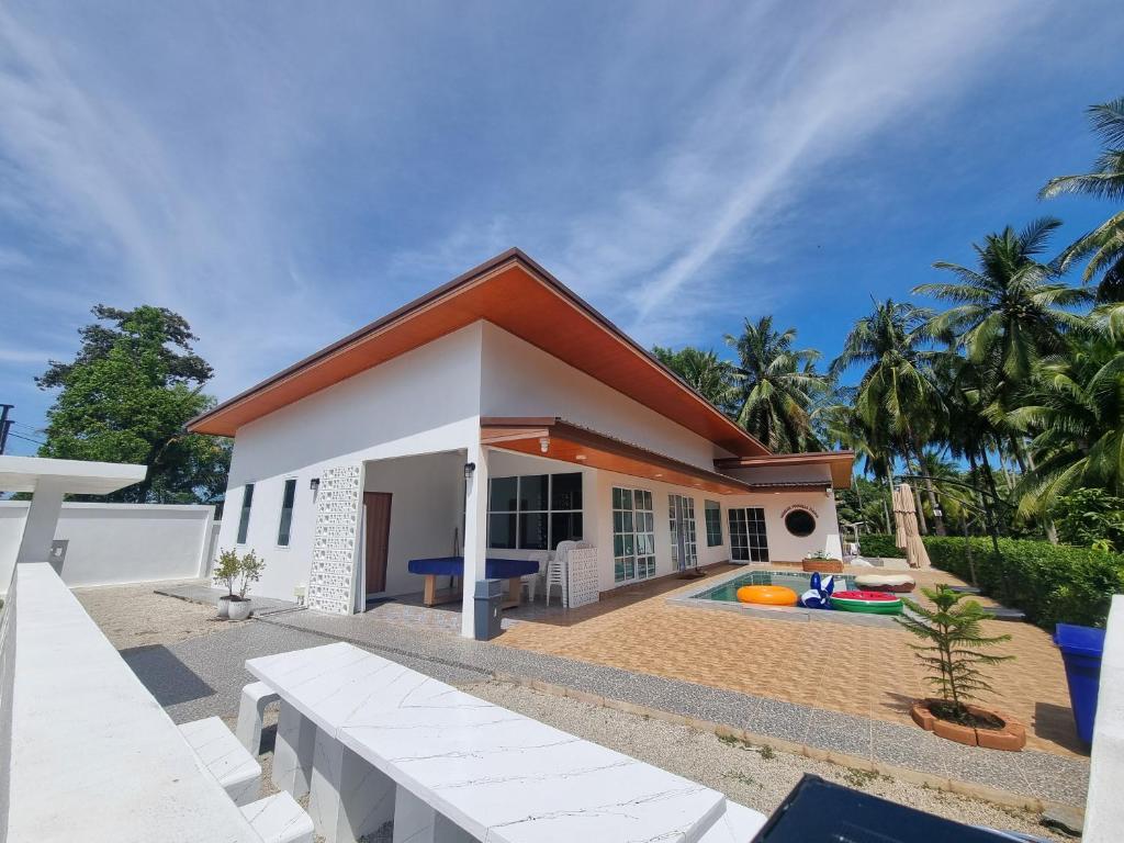 a house with a swimming pool in front of it at Hadkaew Thepha Pool Villa by Jehsana in Ban Krong I Tam