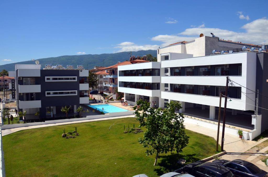 un gran edificio blanco con un césped verde delante de él en Astarti Studios, en Leptokarya