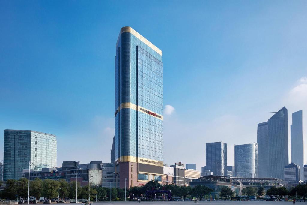 a tall glass building in front of a city at Guangzhou Marriott Hotel Tianhe in Guangzhou