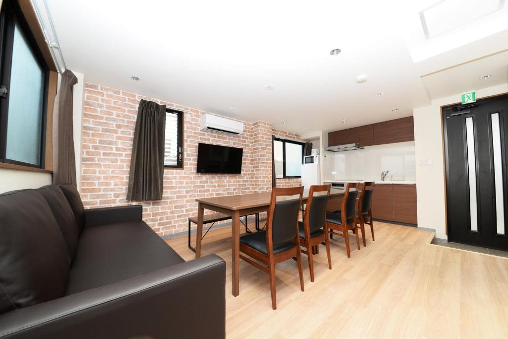 a living room with a couch and a table and chairs at Shinjuku NY House 2 in Tokyo