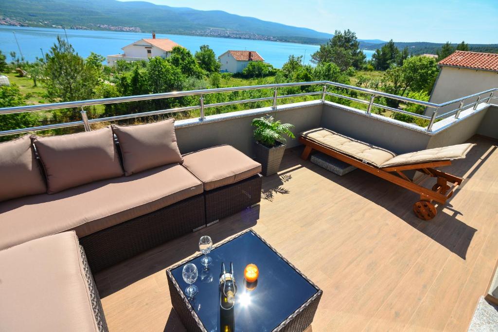 ein Wohnzimmer mit einem Sofa und einem Tisch auf dem Balkon in der Unterkunft Luxury apartment Lavande in Pridraga