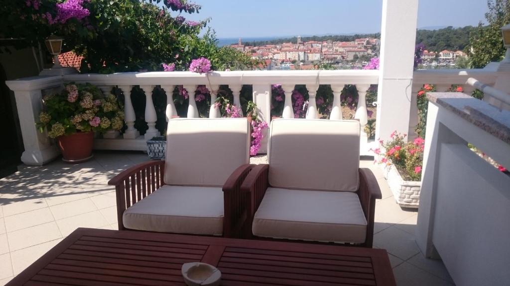 two chairs sitting on a balcony with a view at Guest House Mireja in Rab