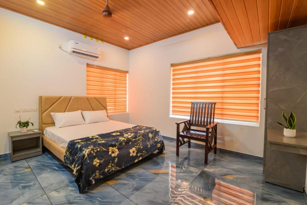a bedroom with a bed and a chair and a window at Star Inn in Cochin