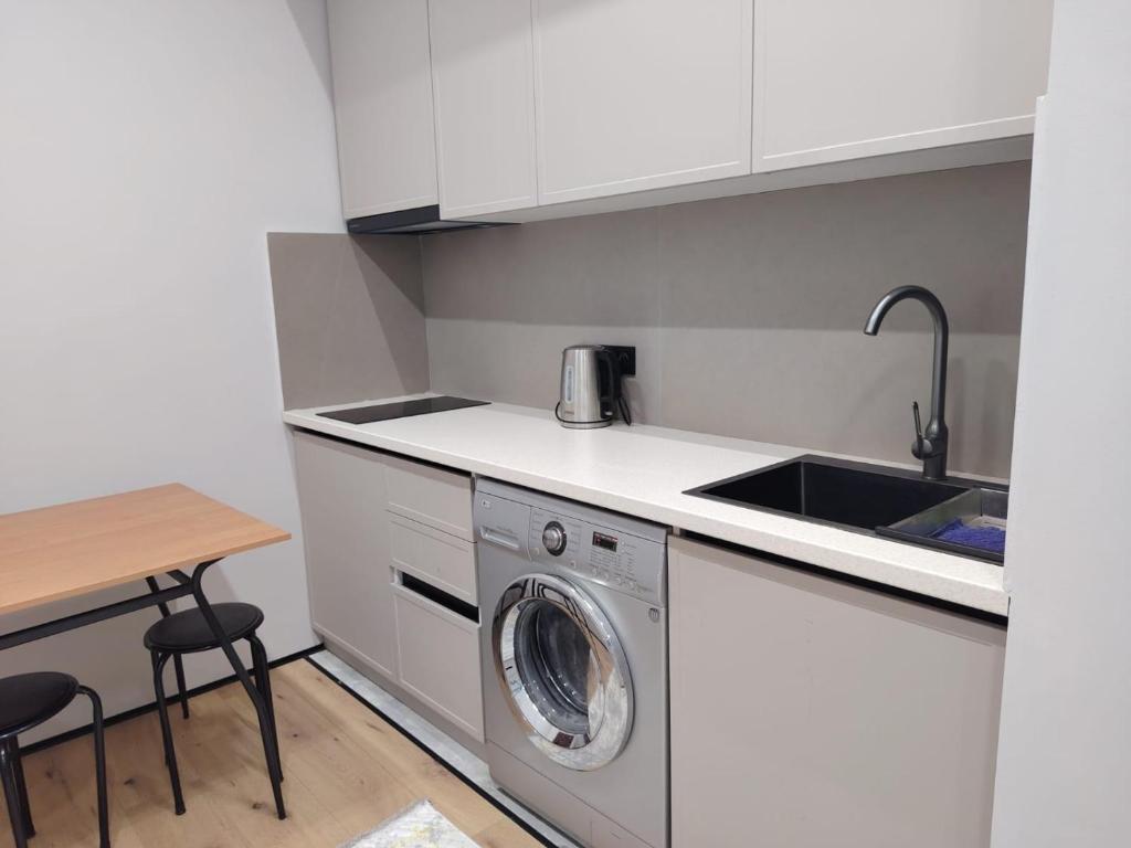 une cuisine avec une machine à laver et un évier dans l'établissement 24 home Aktau, à Aktau