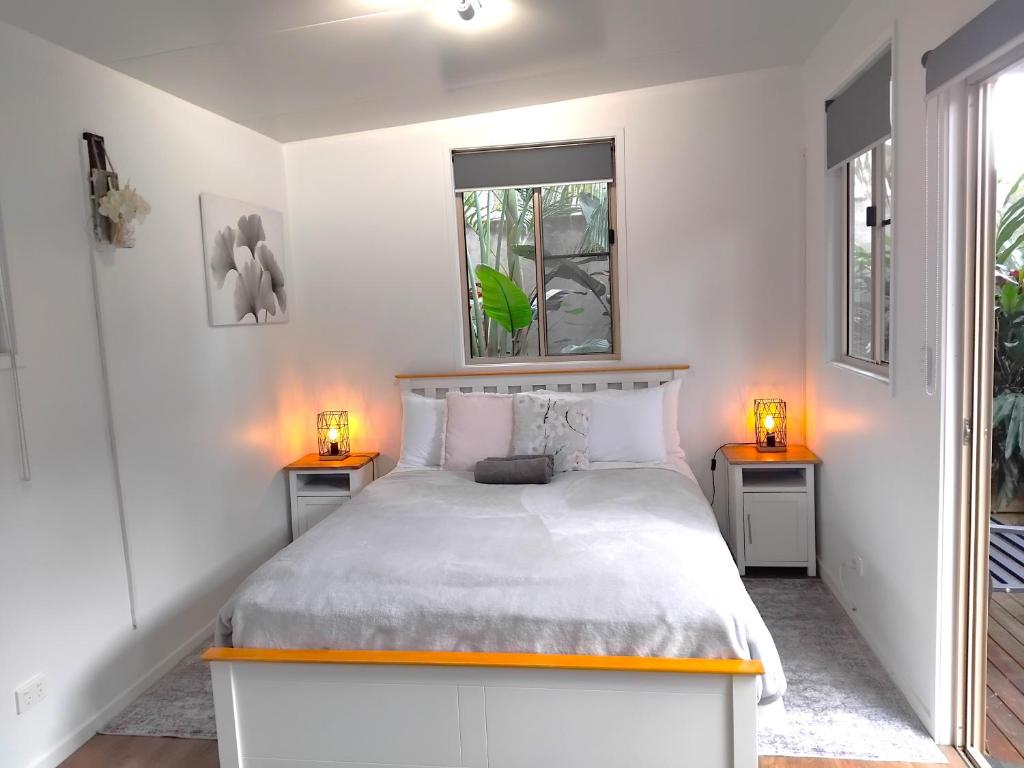 une chambre avec un lit avec deux lampes sur deux tables dans l'établissement Wallaby 3-Bedroom at On Burgum Pond Cottages, à Maleny