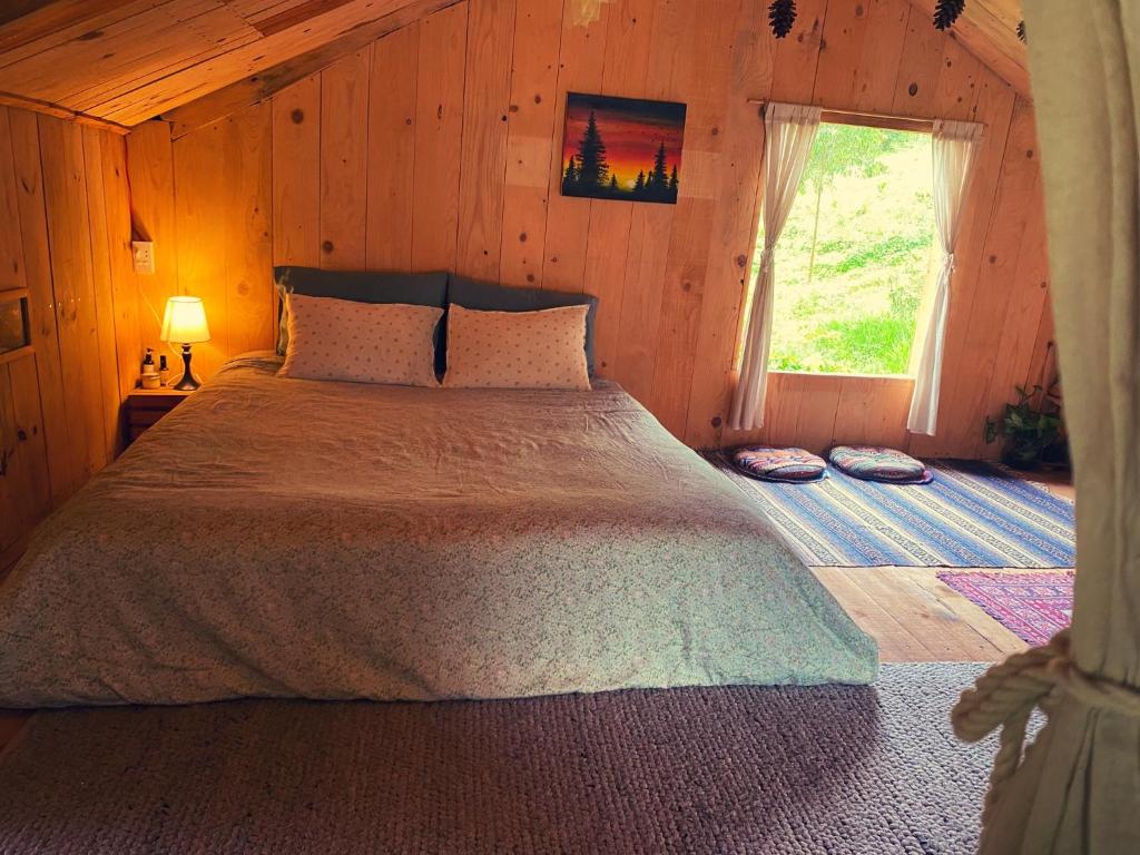 a bedroom with a large bed with a window at Mộc Lan’s House in Phi Liêng