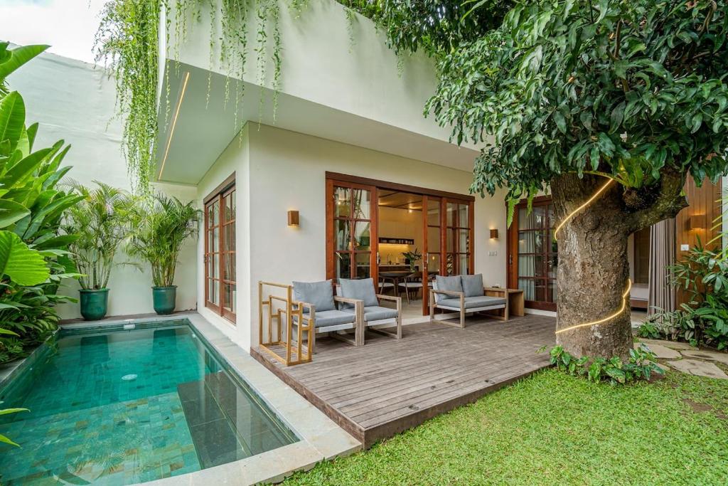 a house with a swimming pool next to a tree at Exclusive townhouse Beachside Excellent location in Sanur