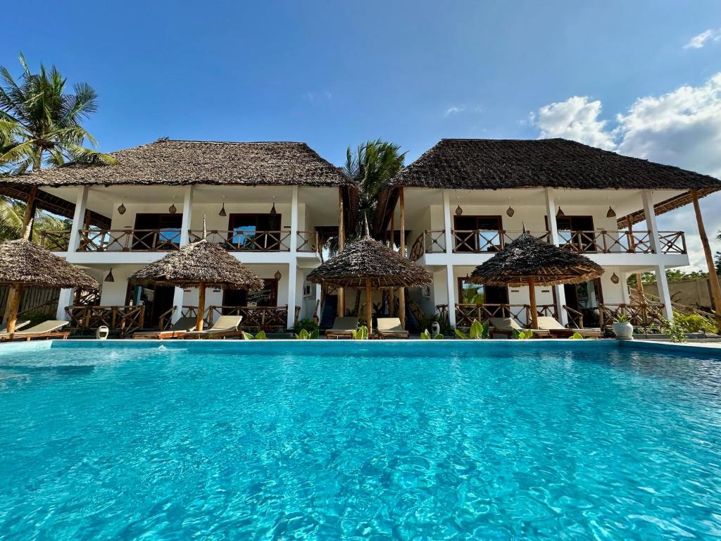 a swimming pool in front of a resort at Pamoja Villas in Migogoni