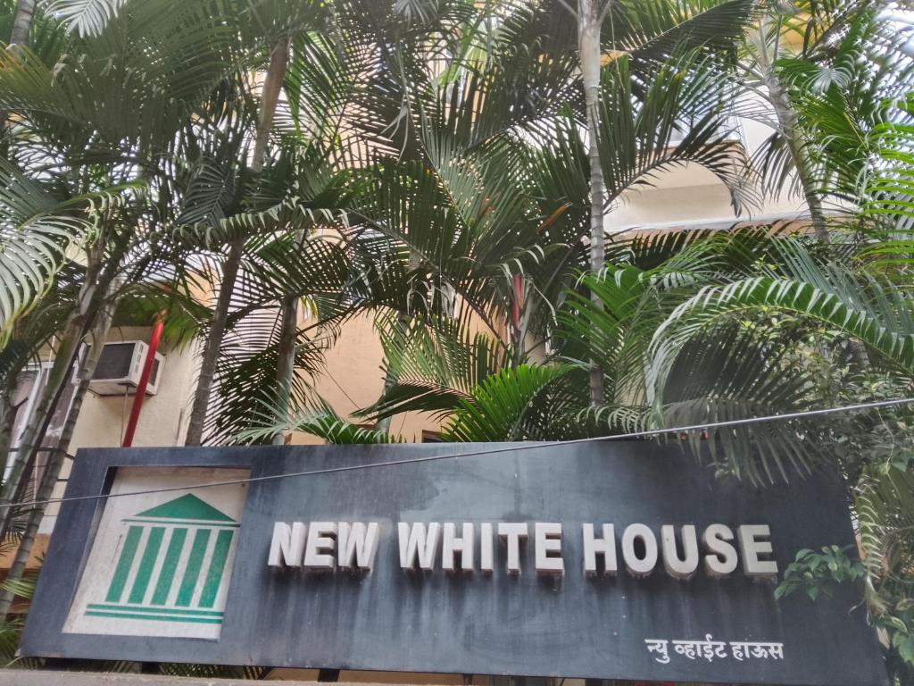 a new white house sign in front of trees at New White House Hotel in Pune