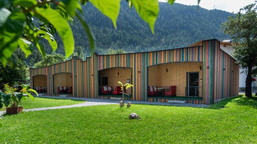 a building with a green yard in front of it at Stadel Chalet Kunterbunt in Ried im Oberinntal