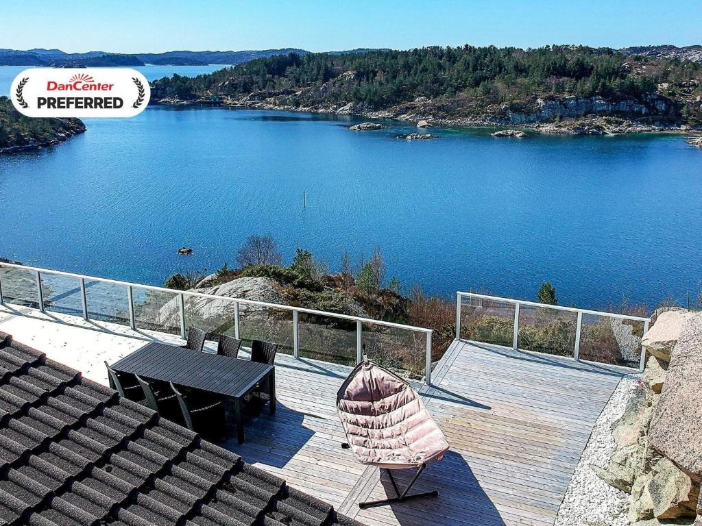 a view of a lake with a table and an umbrella at 12 person holiday home in Fitjar in Fitjar