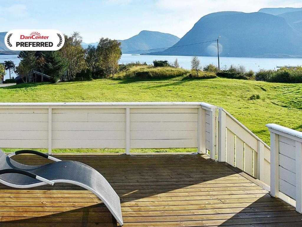 a wooden deck with a fence and a bench on it at 10 person holiday home in MIDSUND in Midsund