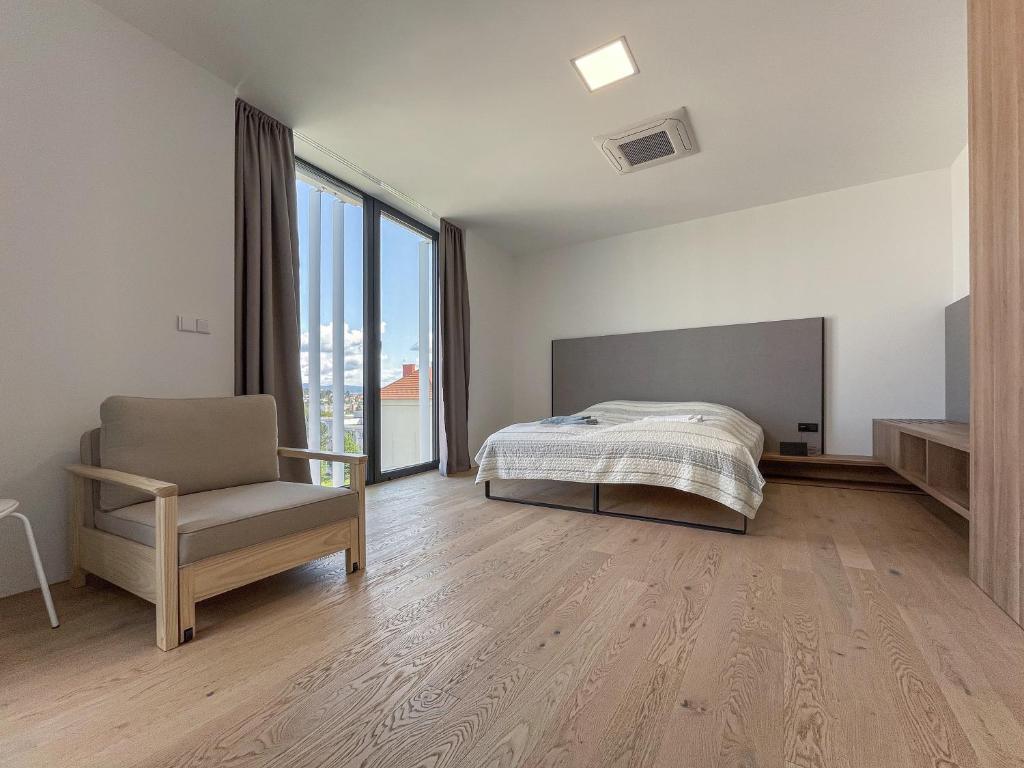 ズリーンにあるPár pokojů microhotel - Štefánikovaのベッドと椅子と窓のある寝室