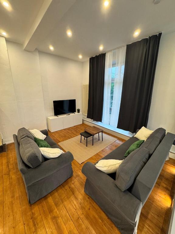a living room with two couches and a flat screen tv at Bavaria Home Modern Living in Geisenfeld