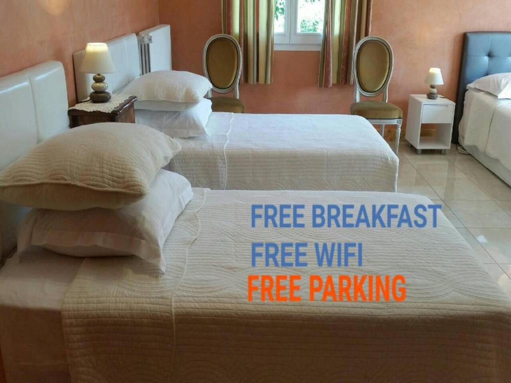 two beds with a free breakfast free wifi sign on them at Chambres D'hôtes du Plessis in Chailles