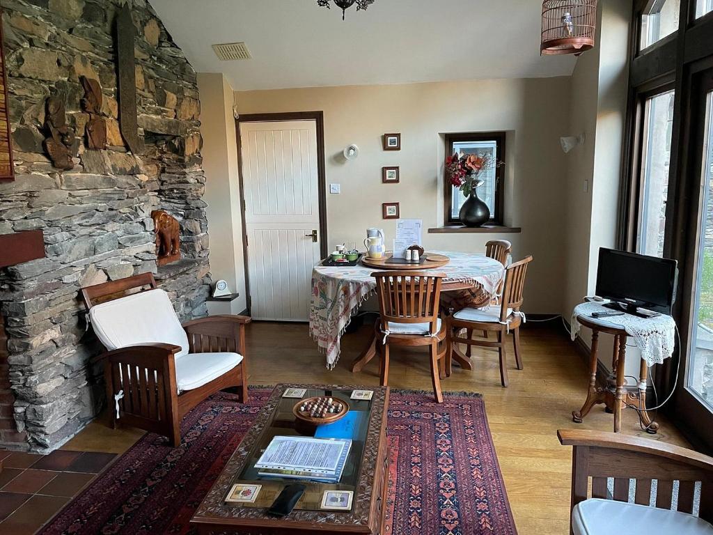 a living room with a table and a stone wall at School House in Patterdale