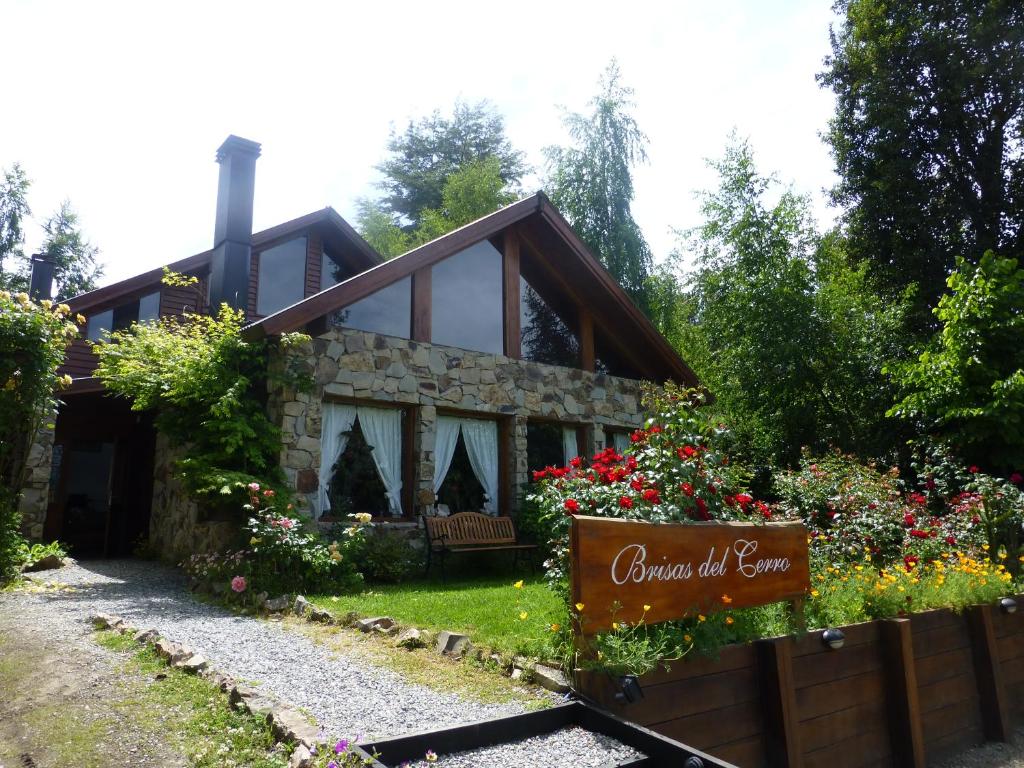 uma casa com um sinal em frente em Hostería Brisas del Cerro em Villa La Angostura