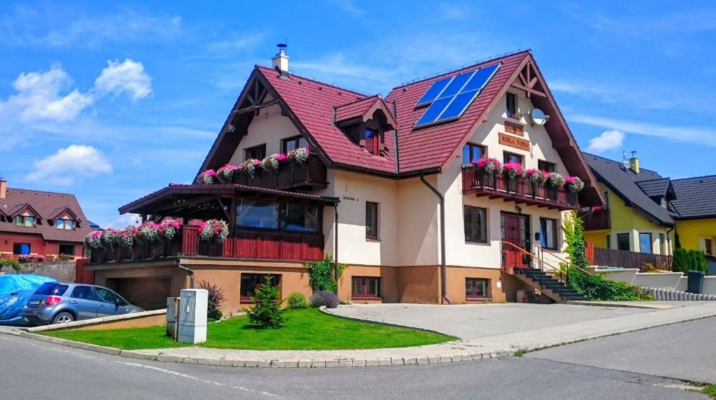 a house with a solar panel on the roof at Penzión Biela Voda in Veľká Lomnica