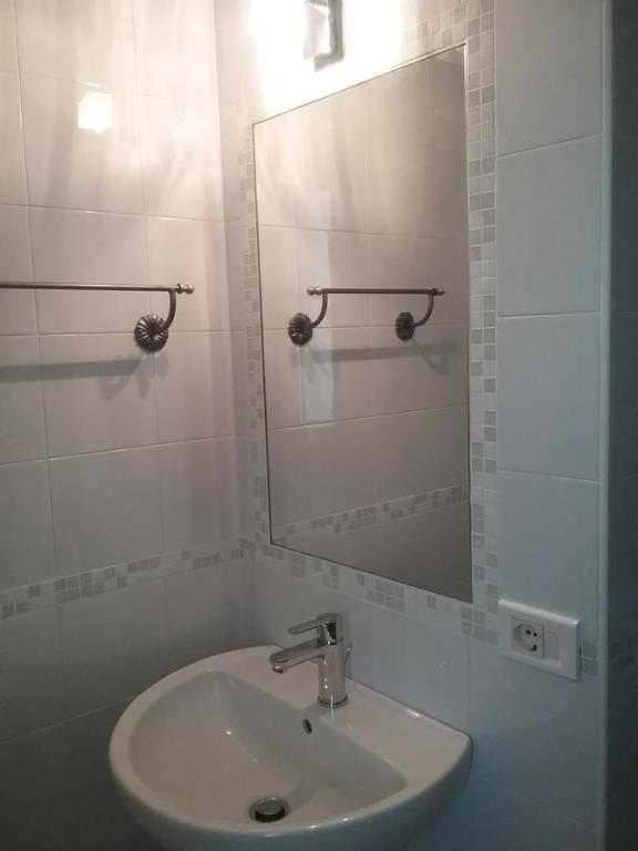 a white bathroom with a sink and a mirror at La controra in Fasano