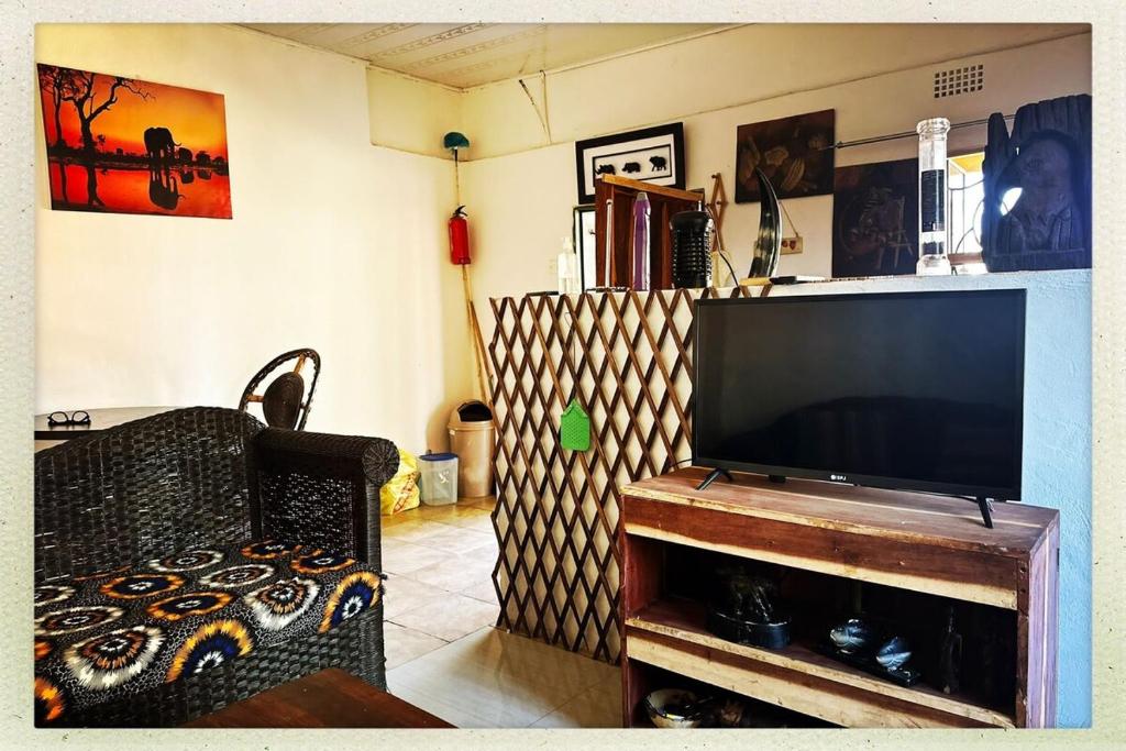 un salon avec une grande télévision à écran plat dans l'établissement Kalibu Cottage offers you a cozy & private home for your holidays, à Livingstone