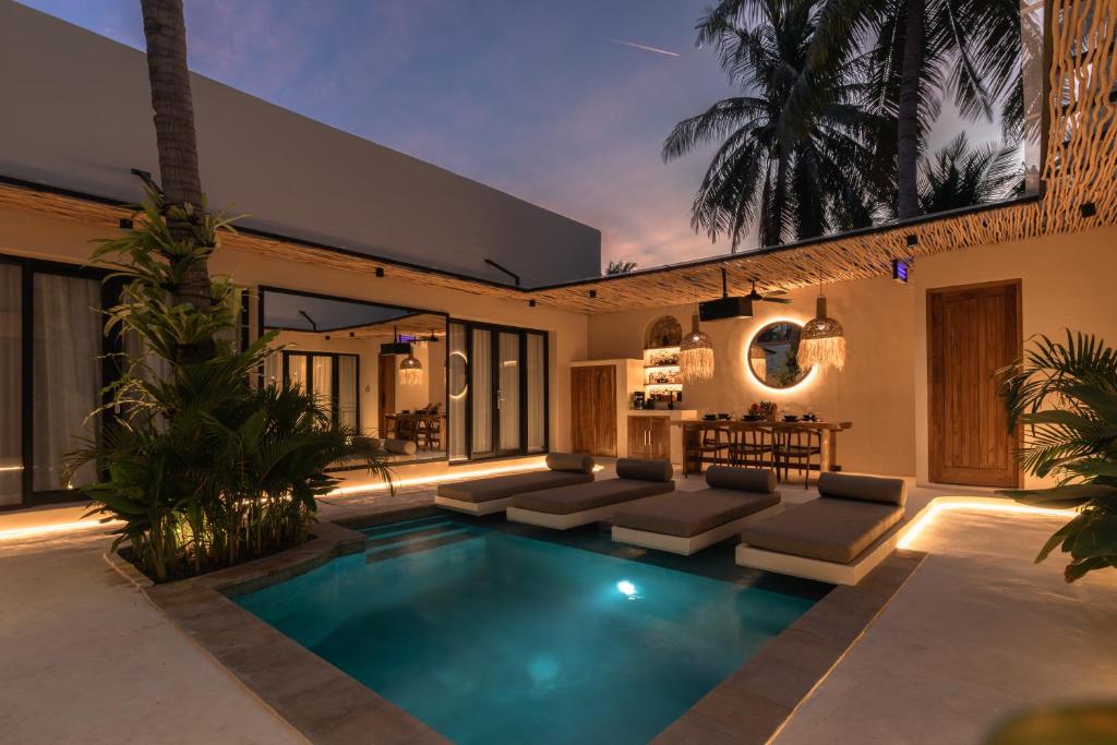 - une piscine dans l'arrière-cour d'une maison dans l'établissement Kaind - Luxury 4BR Villa with Private Pool and Outdoor Cinema on Gili Trawangan, à Gili Trawangan