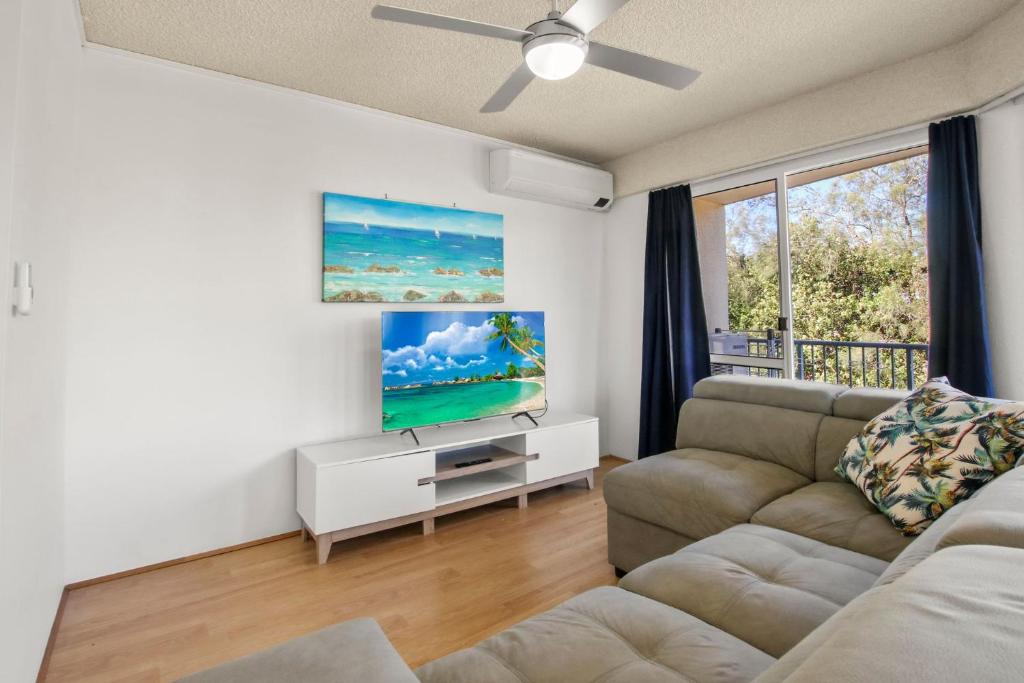 Una sala de estar con un sofá y un televisor de pantalla plana. en Windbourne Unit 11, 101 The Esplanade, Golden Beac, en Golden Beach