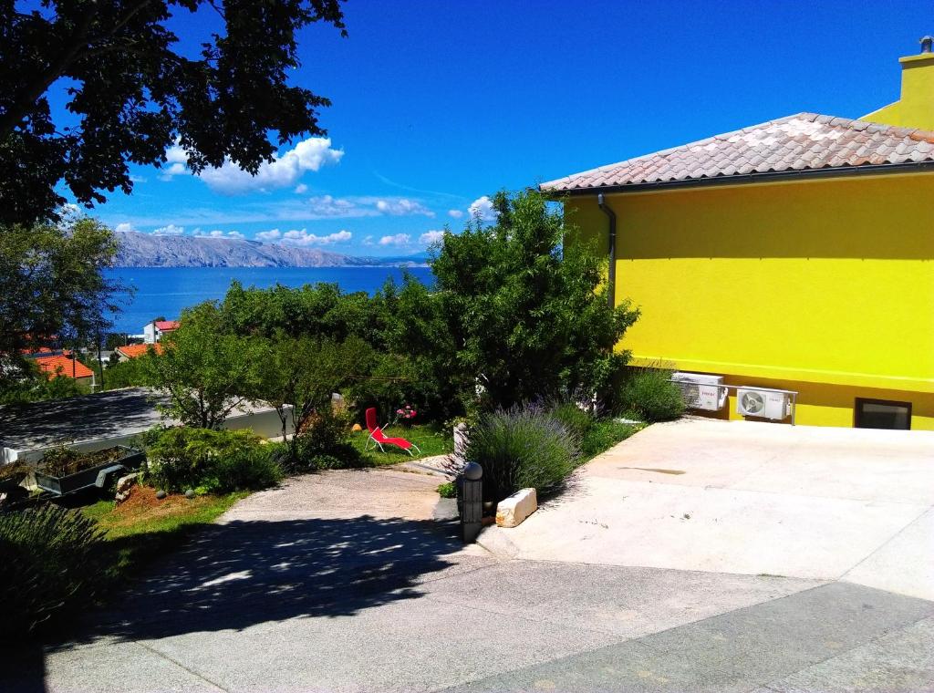 ein gelbes Gebäude mit Blick auf das Wasser in der Unterkunft Villa Beba - Apartments in Senj