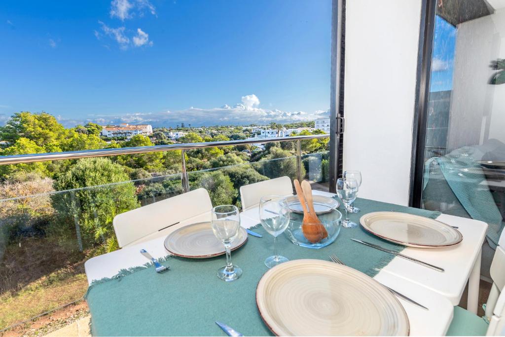 Sa Perdiu 14 Menorca في كالا سانتاندريا: طاولة مع أطباق وكؤوس للنبيذ على شرفة