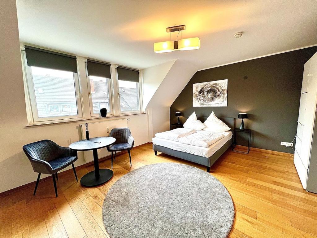 a bedroom with a bed and a table and chairs at Zentral & Ruhig mit Komfort in Niederdorla