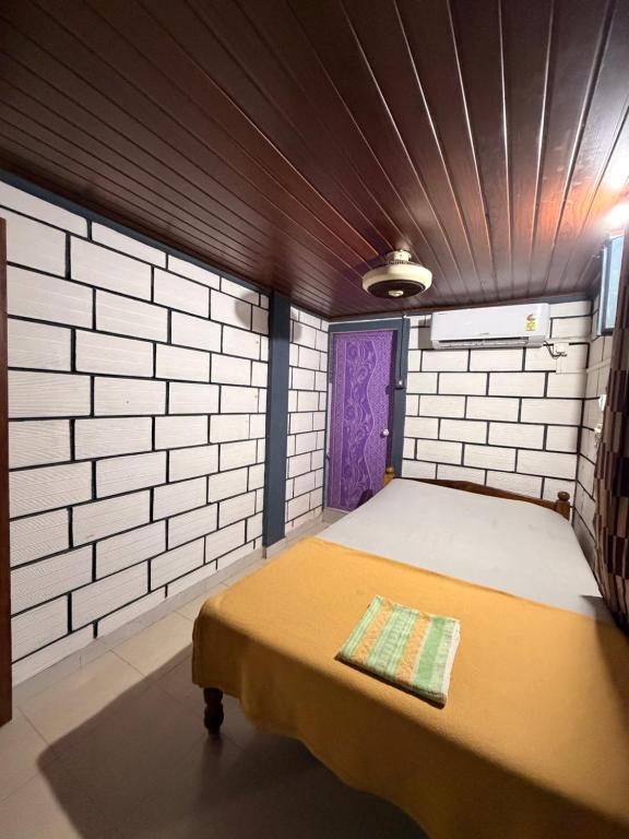 une chambre avec un lit avec une porte violette dans l'établissement Kamal Rooms Ac and non ac, à Gokarna
