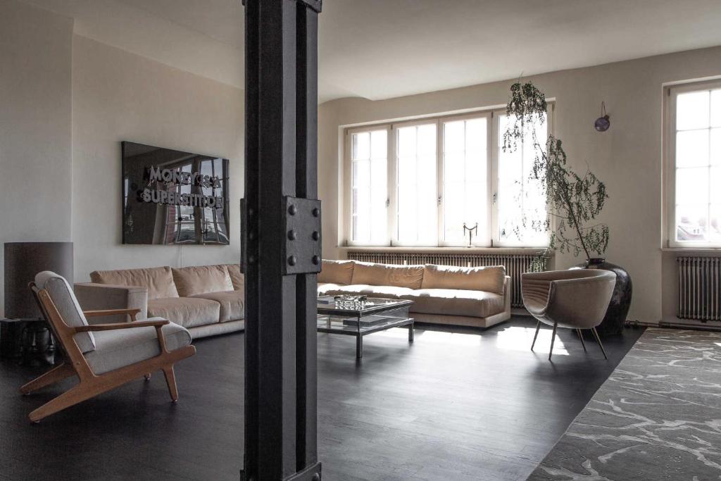 ein Wohnzimmer mit Sofa und Stühlen in der Unterkunft Stadtflucht Homes in Berlin