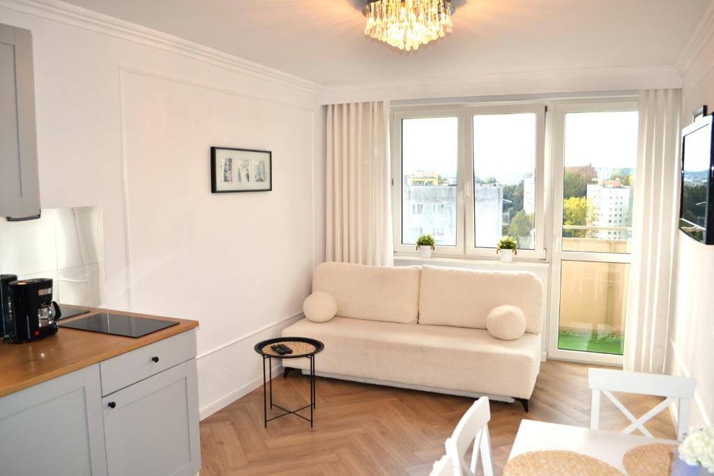 a living room with a couch and a table at Cosy Studio Gdynia Kamienna Góra in Gdynia