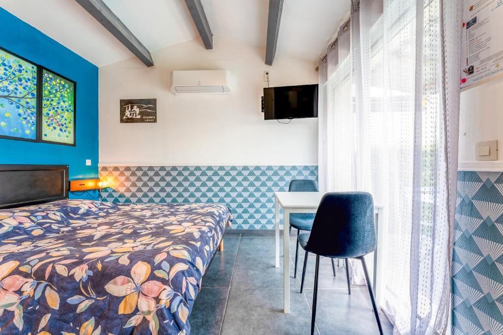 een kamer met een bed, een tafel en stoelen bij Studette Luberon in Les Taillades