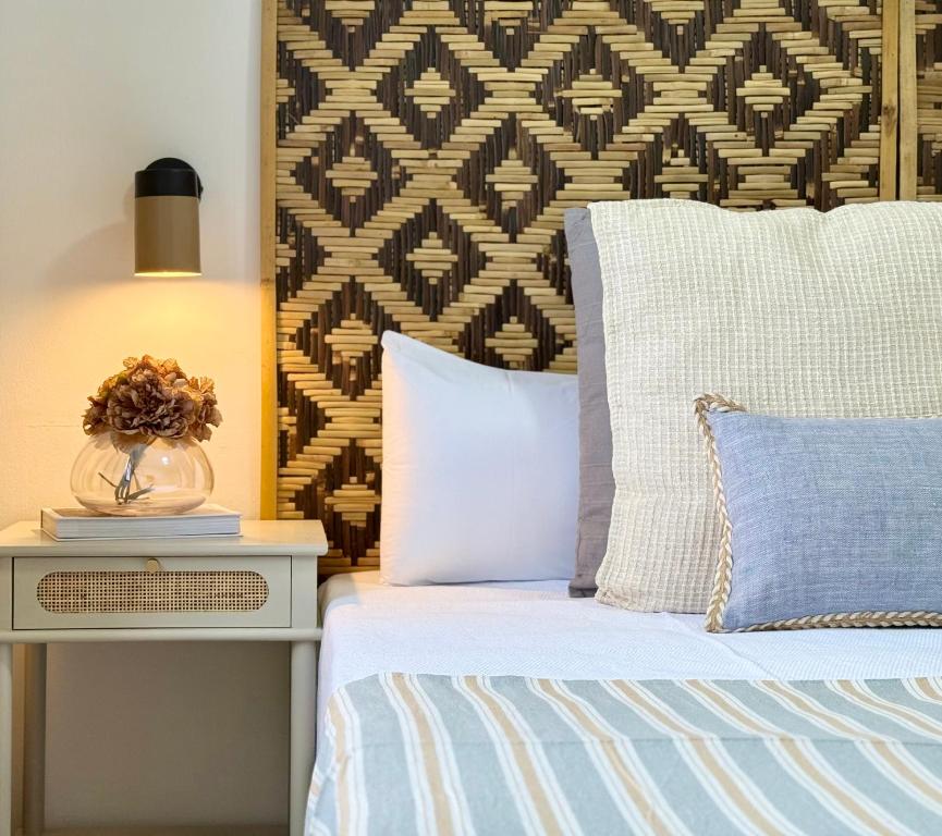 ein Bett mit zwei Kissen und einem Tisch mit einer Lampe in der Unterkunft Canaryislandshost l Coral in Puerto del Carmen