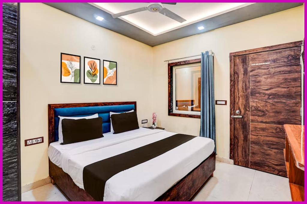 1 dormitorio con 1 cama grande y puerta de madera en Sea Facing Hotel The Dreamland Near Shree Jagannath Temple - Lift-Wifi-Parking and Restaurant Facilities - All Room Sea Facing With Attached Balcony -A luxuary Hotel in Puri, en Cuttack