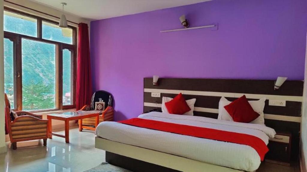 a bedroom with a bed and a purple wall at Hotel Eco-Nest - Best Stay near Bhagsu Waterfall in McLeod Ganj