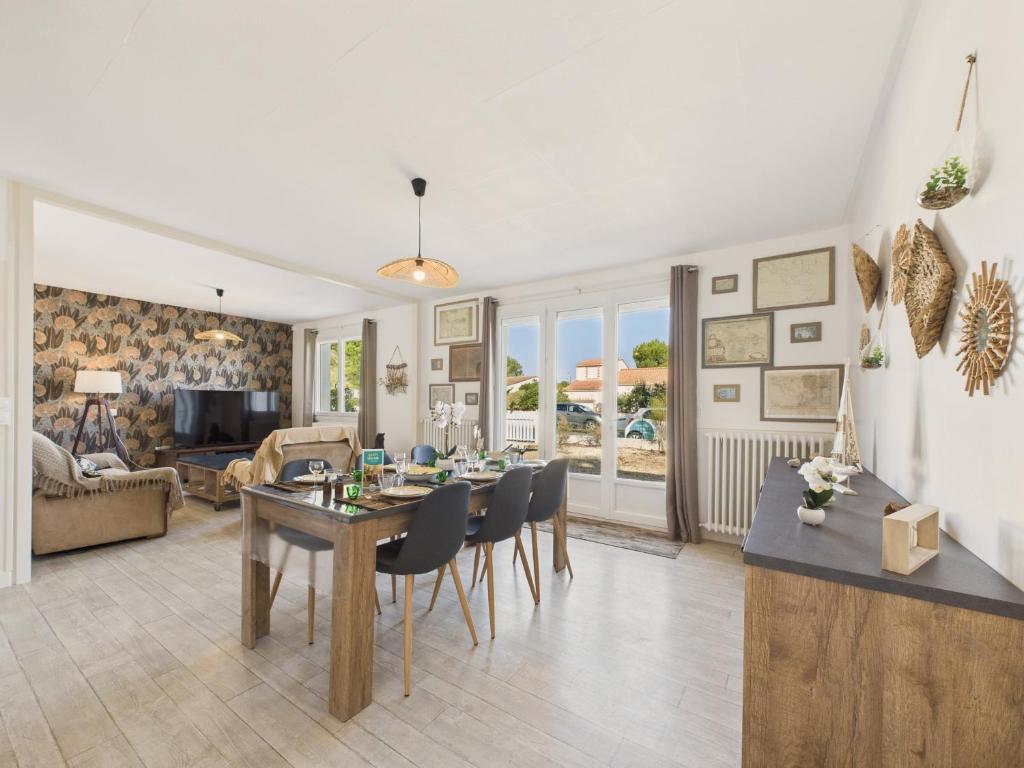 a dining room and living room with a table and chairs at 800 m de la plage - Maison pour 6 avec jardin in La Faute-sur-Mer