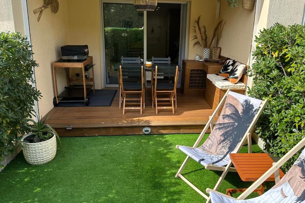 a patio with chairs and a table and a dining room at Cozy studio with pool near the seaside in Roquebrune-sur-Argens